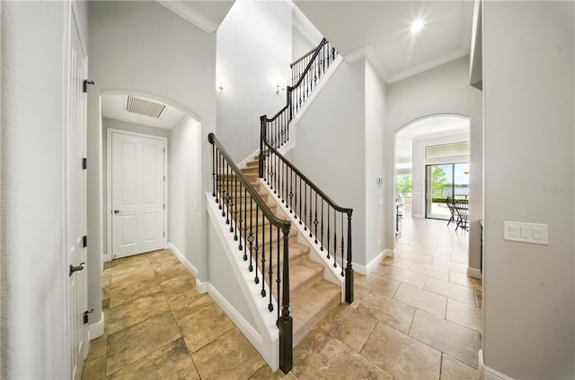 7624 Pointe Venezia Dr, Orlando, FL 32836 - stairway with arched walkways, crown molding, and a towering ceiling