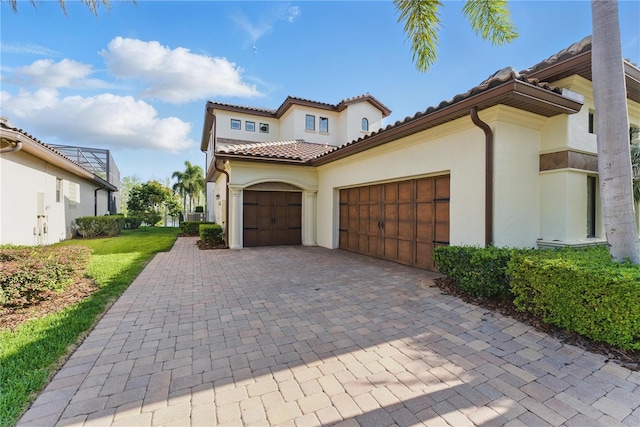7624 Pointe Venezia Dr, Orlando, FL 32836 - mediterranean / spanish home featuring a garage, stucco siding, decorative driveway, and a tile roof