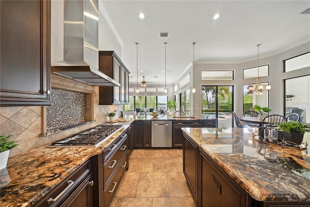 7624 Pointe Venezia Dr, Orlando, FL 32836 - kitchen with wall chimney exhaust hood, appliances with stainless steel finishes, dark brown cabinets, a chandelier, and decorative backsplash