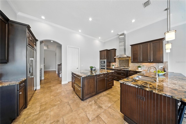 7624 Pointe Venezia Dr, Orlando, FL 32836 - kitchen with wall chimney exhaust hood, arched walkways, decorative backsplash, dark brown cabinetry, and stone counters