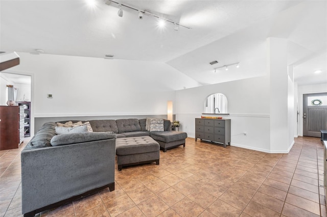 living area with track lighting, vaulted ceiling, visible vents, and light tile patterned floors