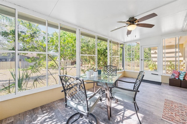 sunroom with a ceiling fan and outdoor dining area