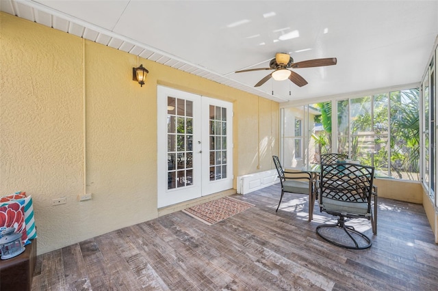 sunroom / solarium with a textured wall, wood finished floors, and french doors