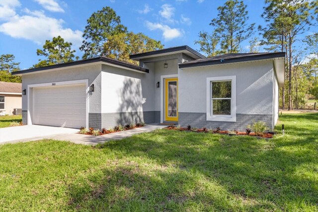 3851 W Wilburton Dr, Citrus Springs, FL 34433 - prairie-style home featuring a front yard, an attached garage, driveway, brick siding, and stucco siding