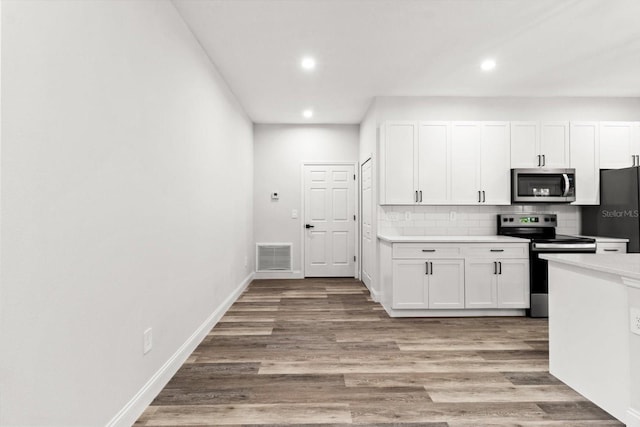 3851 W Wilburton Dr, Citrus Springs, FL 34433 - kitchen featuring recessed lighting, tasteful backsplash, visible vents, white cabinetry, and appliances with stainless steel finishes