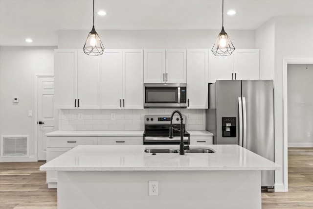 3851 W Wilburton Dr, Citrus Springs, FL 34433 - kitchen featuring visible vents, white cabinets, stainless steel appliances, and a center island with sink