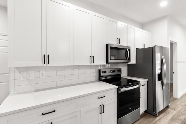 3851 W Wilburton Dr, Citrus Springs, FL 34433 - kitchen with light wood-style flooring, light stone counters, decorative backsplash, appliances with stainless steel finishes, and white cabinets