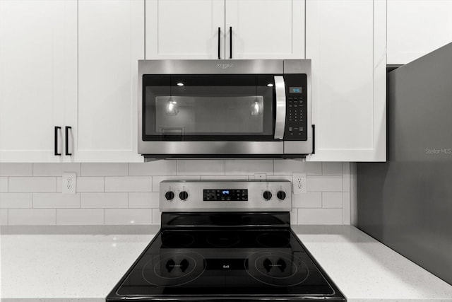 3851 W Wilburton Dr, Citrus Springs, FL 34433 - kitchen with white cabinetry, light stone countertops, stainless steel appliances, and decorative backsplash