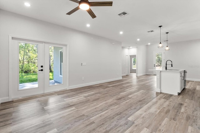 3851 W Wilburton Dr, Citrus Springs, FL 34433 - unfurnished living room with a ceiling fan, a wealth of natural light, french doors, and a sink
