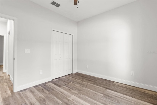 3851 W Wilburton Dr, Citrus Springs, FL 34433 - unfurnished bedroom featuring wood finished floors, a closet, ceiling fan, baseboards, and visible vents