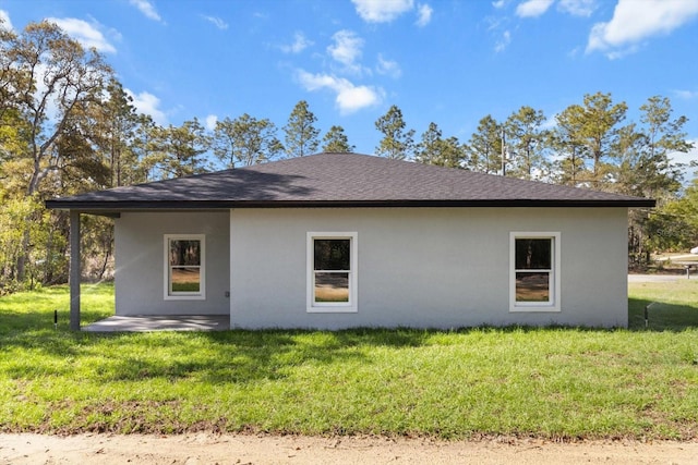 3851 W Wilburton Dr, Citrus Springs, FL 34433 - view of home's exterior featuring a lawn, stucco siding, and roof with shingles