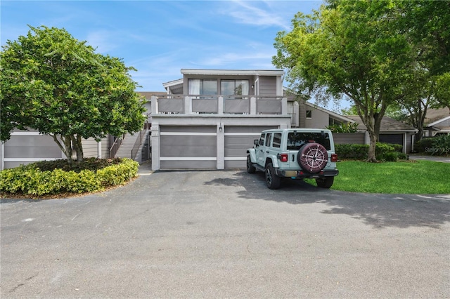 townhome / multi-family property with driveway, a garage, and a balcony