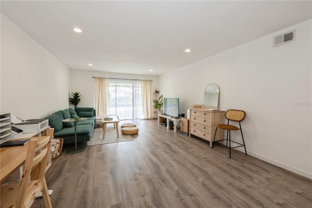 living area featuring recessed lighting, visible vents, and wood finished floors