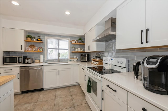 kitchen featuring a sink, stainless steel appliances, decorative backsplash, open shelves, and wall chimney exhaust hood