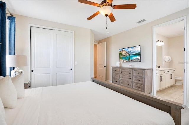 bedroom with a sink, ensuite bath, a ceiling fan, visible vents, and a closet