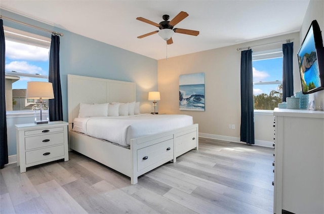 bedroom featuring light wood-style floors, baseboards, and ceiling fan