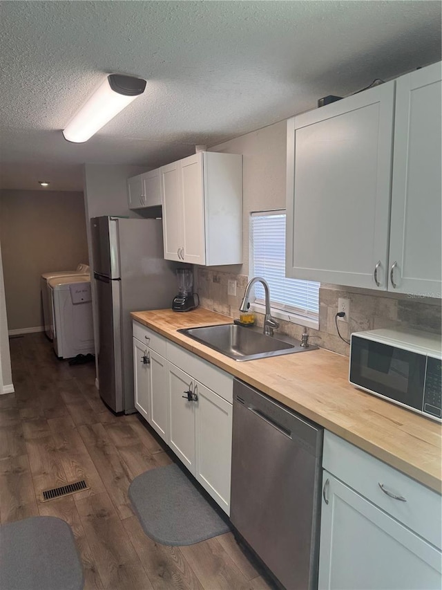 9400 SE 119th St, Belleview, FL 34420 - kitchen with stainless steel appliances, visible vents, a sink, washing machine and dryer, and butcher block countertops