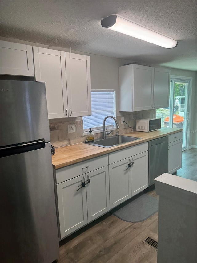 9400 SE 119th St, Belleview, FL 34420 - kitchen featuring decorative backsplash, stainless steel appliances, a textured ceiling, and a sink