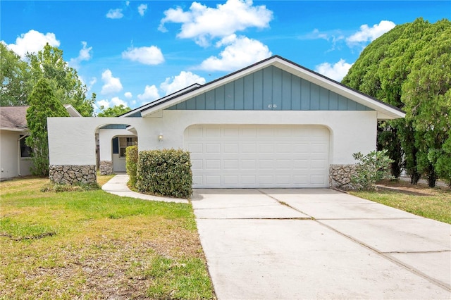 single story home featuring concrete driveway, stucco siding, a front yard, and a garage