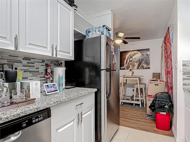 741 Hillview Dr, Altamonte Springs, FL 32714 - kitchen featuring decorative backsplash, appliances with stainless steel finishes, white cabinets, a ceiling fan, and light tile patterned flooring