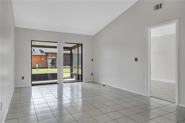 empty room featuring baseboards, vaulted ceiling, light tile patterned flooring, and visible vents