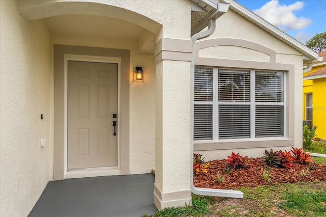 entrance to property with stucco siding