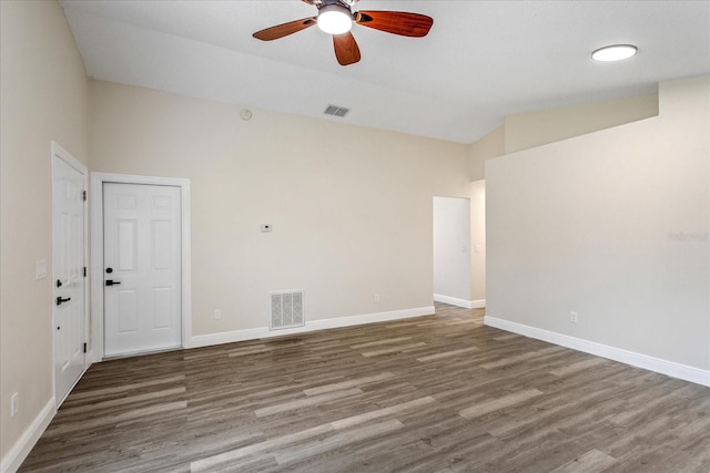 spare room featuring visible vents, wood finished floors, a ceiling fan, and lofted ceiling
