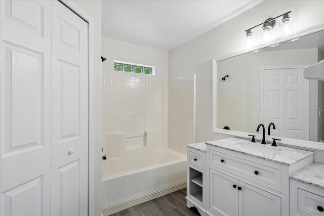 bathroom featuring shower / tub combination, wood finished floors, vanity, and a closet