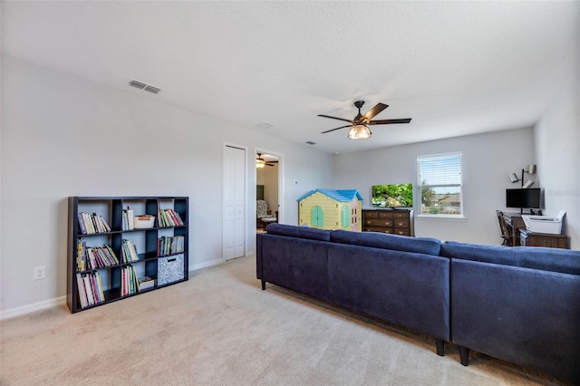 living area with baseboards, a ceiling fan, visible vents, and carpet flooring