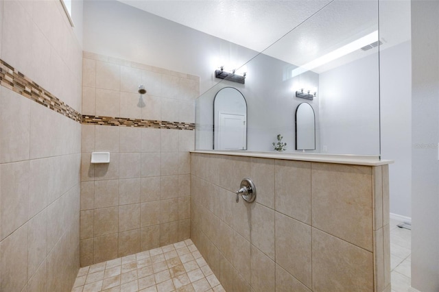 bathroom with visible vents and tiled shower