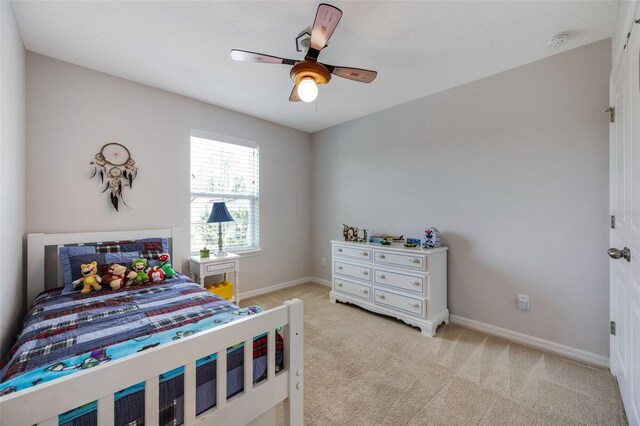 bedroom featuring a ceiling fan, baseboards, and light carpet