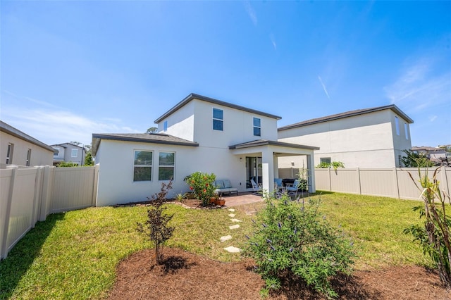 back of property featuring a fenced backyard, a yard, and a patio