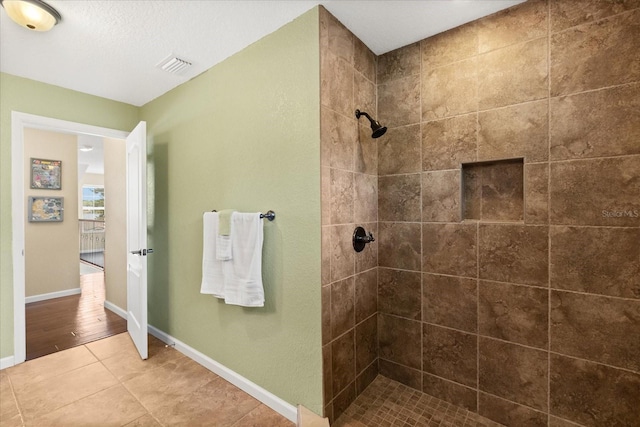 955 Seminole St, Clermont, FL 34711 - bathroom featuring visible vents, baseboards, tile patterned floors, and tiled shower