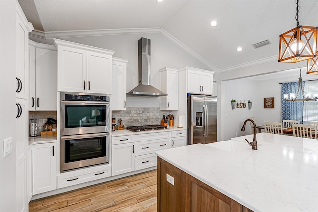 42368 W Cashew Ct, Eustis, FL 32736 - kitchen featuring a chandelier, stainless steel appliances, visible vents, wall chimney exhaust hood, and lofted ceiling