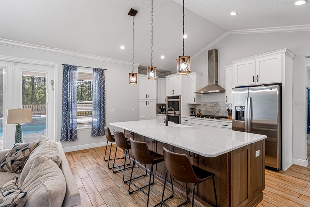42368 W Cashew Ct, Eustis, FL 32736 - kitchen with ornamental molding, appliances with stainless steel finishes, wall chimney range hood, and vaulted ceiling