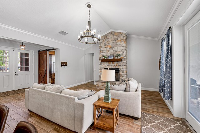 42368 W Cashew Ct, Eustis, FL 32736 - living room featuring a chandelier, a barn door, crown molding, light wood-style flooring, and lofted ceiling