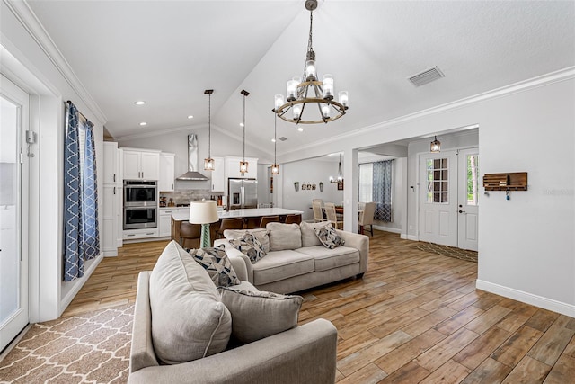 42368 W Cashew Ct, Eustis, FL 32736 - living area featuring light wood finished floors, an inviting chandelier, visible vents, ornamental molding, and lofted ceiling