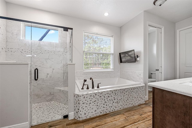 42368 W Cashew Ct, Eustis, FL 32736 - bathroom featuring a wealth of natural light, wood finished floors, a shower stall, and a bath