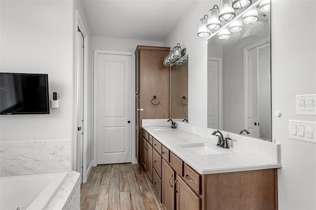 42368 W Cashew Ct, Eustis, FL 32736 - bathroom featuring a whirlpool tub, double vanity, a sink, and wood finished floors