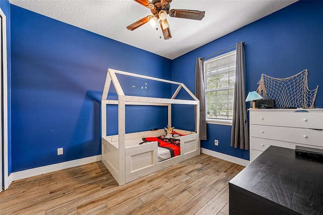 42368 W Cashew Ct, Eustis, FL 32736 - bedroom featuring a textured ceiling, ceiling fan, wood finished floors, and baseboards