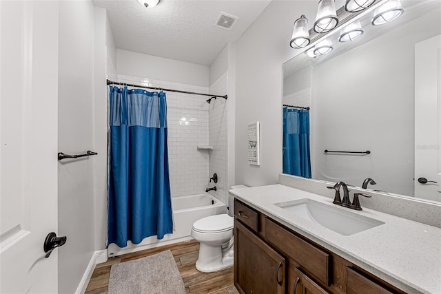 42368 W Cashew Ct, Eustis, FL 32736 - bathroom featuring shower / bathtub combination with curtain, toilet, visible vents, a textured ceiling, and wood finished floors