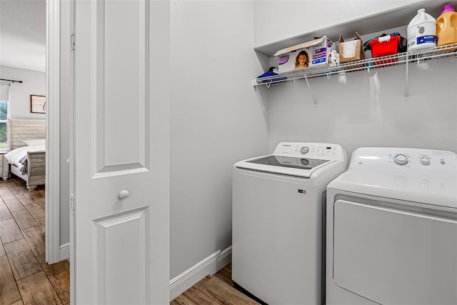 42368 W Cashew Ct, Eustis, FL 32736 - laundry room with wood finished floors, baseboards, laundry area, and washing machine and dryer