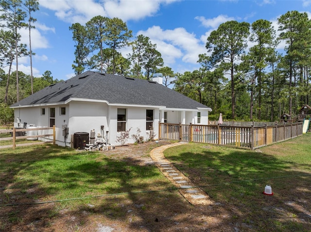 42368 W Cashew Ct, Eustis, FL 32736 - back of house with stucco siding, a yard, a shingled roof, and a fenced backyard