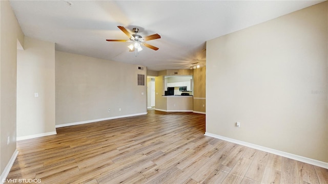 spare room with baseboards, ceiling fan, and wood finished floors