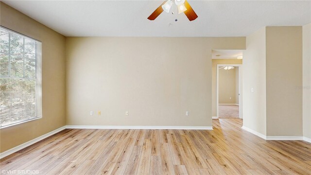 empty room featuring ceiling fan, baseboards, and light wood-type flooring