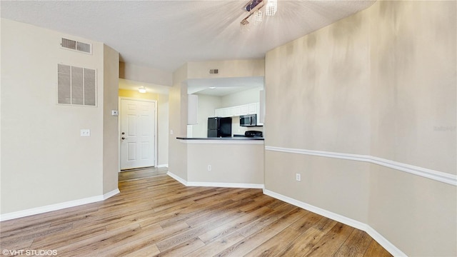 unfurnished room featuring visible vents and light wood-type flooring