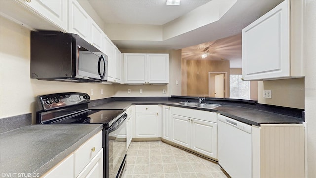 kitchen featuring white dishwasher, dark countertops, black electric range oven, and a sink