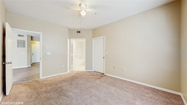unfurnished bedroom with baseboards, visible vents, light carpet, and ensuite bathroom