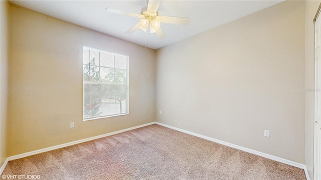 carpeted empty room featuring a ceiling fan and baseboards