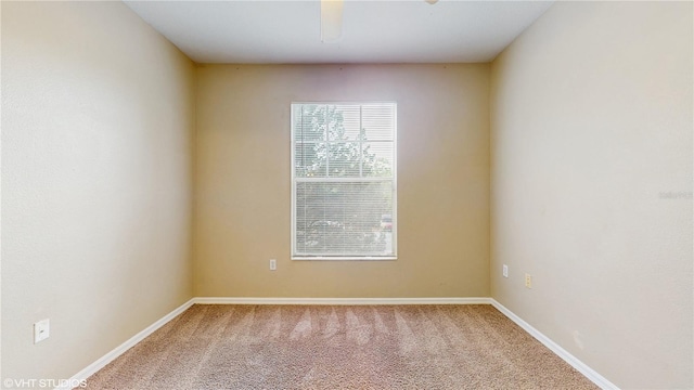 carpeted empty room featuring baseboards